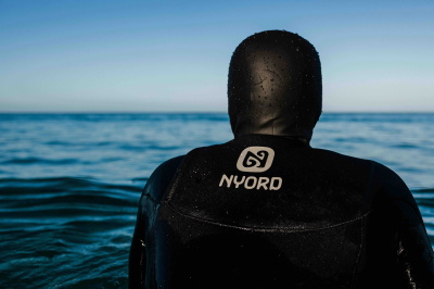 Surfer wearing a Nyord wetsuit on the beach